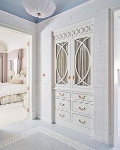 a bedroom with white furniture and blue walls