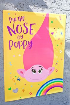 a sign that says pin the nose on poppy with an image of a pink troll