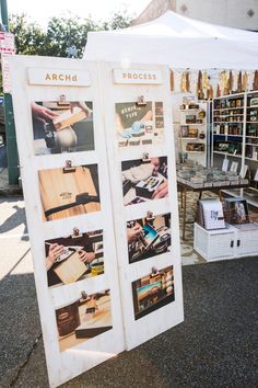 two signs with pictures on them sitting in front of a book stand and other books