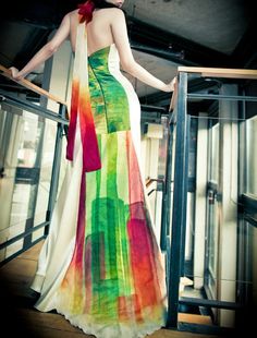 a woman in a colorful dress is standing on the stairs