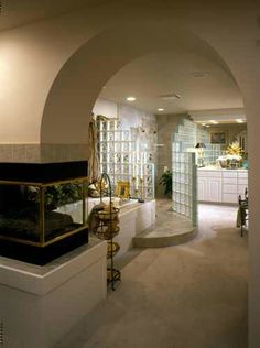 a large room with an arch leading into the kitchen