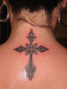 a woman with a tattoo on her back neck and cross in the middle of it