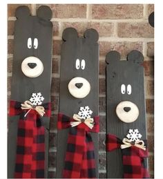 three black bears with snowflakes on them are hanging from the side of a brick wall