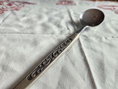 a spoon sitting on top of a white table cloth