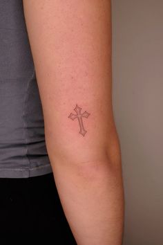 a woman with a cross tattoo on her arm