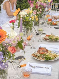 two women sitting at a table with plates of food