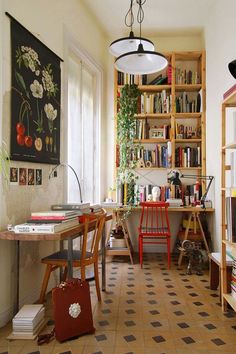 a room filled with lots of books next to a desk and shelves full of books