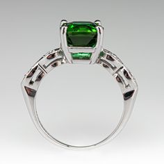 This balanced ring is centered with one (1) square cushion cut vivid green tourmaline set into a four-prong head. The shoulders of the ring are each accented with two (2) bead set round brilliant cut diamonds. The ring measures 8.2mm at the top, rises 7.1mm above the finger, tapering to 1.3mm wide and 0.7mm thick at the base of the shank. The ring is crafted in platinum and is currently a size 6. Diamond Ring Platinum, Bead Set, Green Tourmaline, Round Brilliant Cut Diamond, Cushion Cut, Brilliant Cut Diamond, Round Brilliant, Tourmaline, Diamond Ring