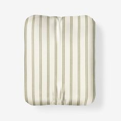 a white and green striped pillow on top of a bed