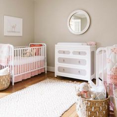 a baby's room with two cribs and a rug on the floor