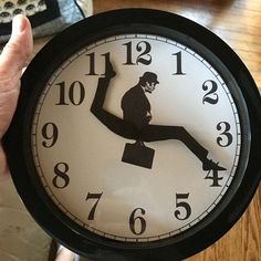 a person holding a black and white clock with the image of a man on it