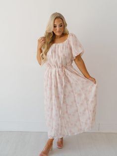 Twirl around in the "Jocelyn Maxi Dress!" This feminine ensemble would make for the most dainty and charming baby shower outfit! It features lightweight fabric with pink embroidered flowers throughout. The scoop neckline is complimented by the puffed balloon sleeves! Effortlessly pair with any sandals or heels! Detailed Fit: Swoop neckline maxi dress Pink and white floral detail with neutral embroidered flowers Cinching through the neckline Adjustable/removable belt at the waist line Overall Fit Pink Square Neck Floral Dress For Spring, Modest Floral Embroidered Summer Dress, Modest Floral Embroidery Summer Dress, Modest Summer Dress With Floral Embroidery, Scoop Neck Spring Brunch Dress, Scoop Neck Dress For Spring Brunch, Modest Square Neck Summer Dress, Spring Brunch Dresses With Scoop Neck, Modest Square Neck Dress For Spring