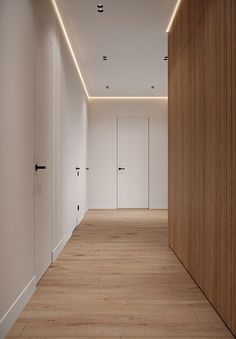 an empty room with white walls and wooden floors is lit by recessed lighting on the ceiling