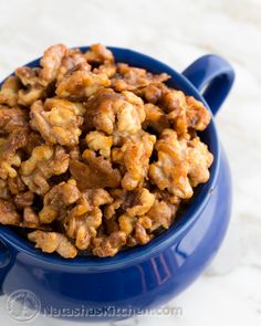 a blue bowl filled with walnuts on top of a table