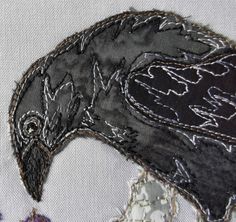 an embroidered bird is shown on the side of a piece of fabric with stitching