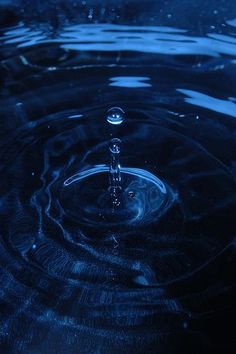 a water droplet is shown in the middle of a blue pool with ripples