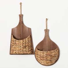 two wooden utensils hanging from hooks on a wall