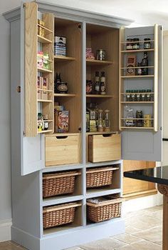 an open pantry door in the middle of a kitchen with shelves full of food and condiments