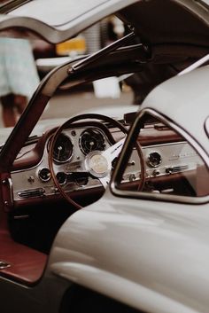 the interior of an old car with wood trim and steering wheel, including dash board