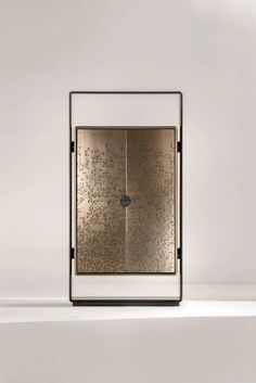 a gold and black cabinet sitting on top of a white counter next to a wall