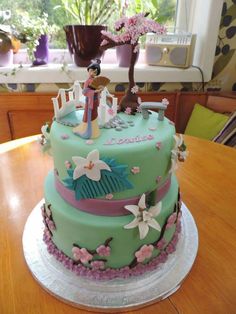 there is a green cake with pink flowers on the table and a figurine