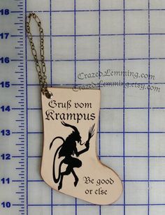 a wooden ornament with an image of a devil on it and the words grub from kramus be good or else