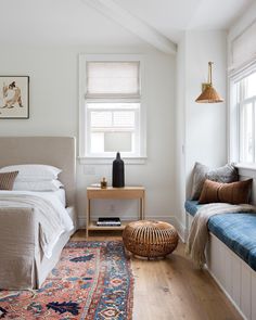 a bed sitting next to a window in a bedroom on top of a wooden floor