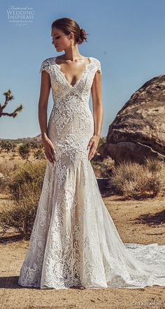 a woman standing in the desert wearing a wedding dress with an open back and sleeves