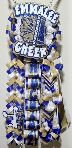 a blue and white cheer ribbon hanging from the side of a wall