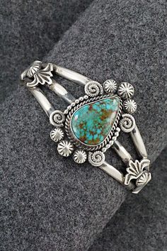 This stunning Kingman turquoise and sterling silver bracelet was made by Navajo silversmith Rosita Calladitto. The back is signed R Calladitto and stamped Sterling.Size: 5 5/8" (will fit up to a 6 3/4" wrist)Gap: 1 1/8"Width: 1 5/8"Cuff Width: 1/2"Free shipping on all orders! We ship with USPS and always include tracking. All orders ship within a day of payment.Returns are accepted up to 30 days after you receive your order. Just send us a message. Our shop offers cash back or store credit. The Unique Engraved Turquoise Jewelry, Elegant Turquoise Engraved Sterling Silver Bracelet, Elegant Engraved Turquoise Sterling Silver Bracelet, Western Style Bangle Jewelry Gift, Western Style Bangle Jewelry As Gift, Western Style Bangle As Gift, Unique Turquoise Sterling Silver Bracelets, Engraved Turquoise Southwestern Jewelry, Elegant Sterling Silver Bracelet With Turquoise