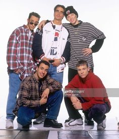 four young men posing for a photo in front of a white background