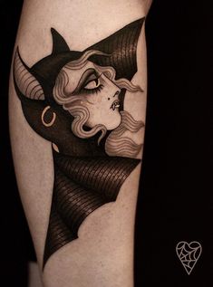 a woman's face with horns and hair on her leg, done in black ink