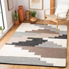 a living room with a chair, rug and pictures on the wall