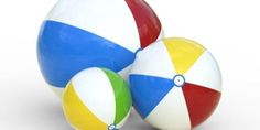 two colorful beach balls sitting next to each other