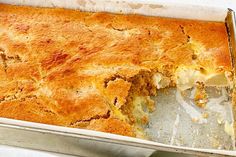 a casserole in a metal pan with a piece taken out of it's side