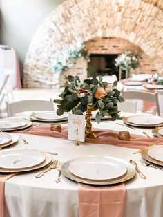 the table is set with white plates and place settings for an elegant dinner party or reception