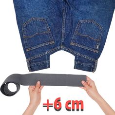 two hands holding a pair of jeans with the length between them