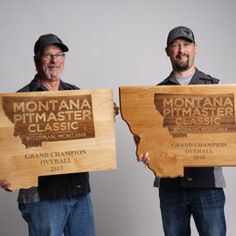 two men holding up wooden signs that say montana pimaster classic