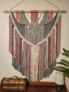 the wall hanging is made from yarn and wood