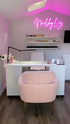 a pink chair sitting in front of a desk with a neon sign on top of it