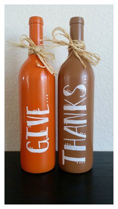 two orange and brown wine bottles sitting next to each other on top of a table