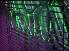 the blinds in this room are covered with green and purple lights, as well as bicycles on them