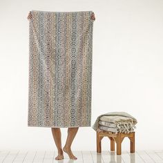 a woman is standing in front of a towel