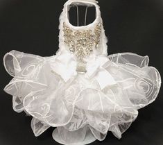 a white dress made out of tulle and fabric with gold sequins on it