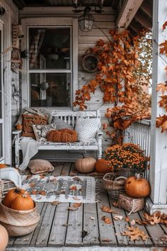 a porch covered in lots of pumpkins and leaves