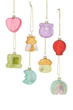 six glass ornaments hanging from strings on a white background