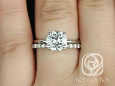 a woman's hand with a diamond ring on top of her finger and the engagement band