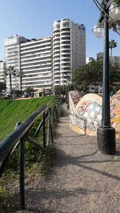 a walkway with graffiti on the side next to tall buildings