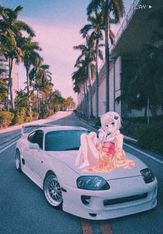 a woman sitting on the hood of a white sports car in front of palm trees