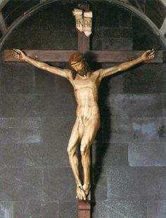 the crucifix is in front of a stone wall